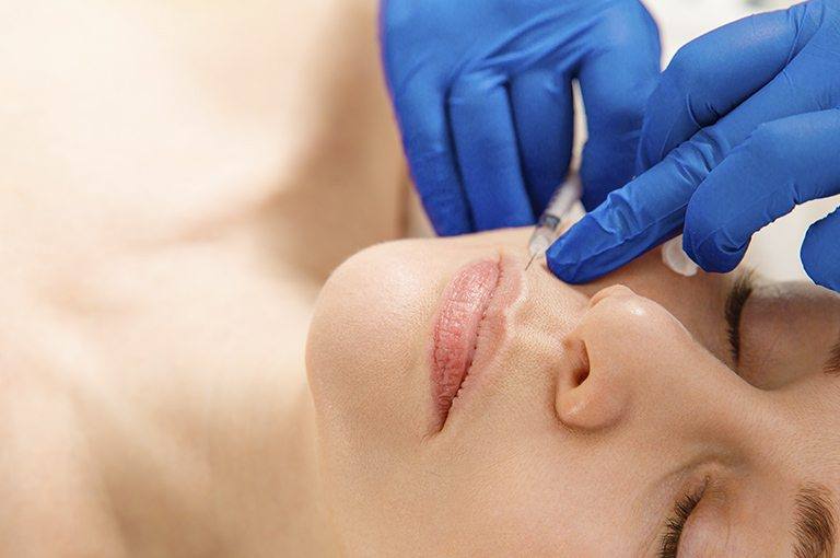 Mujer tratanto sus arrugas en el labio superior. Clínica Fernández. Cirugía Estética en Asturias